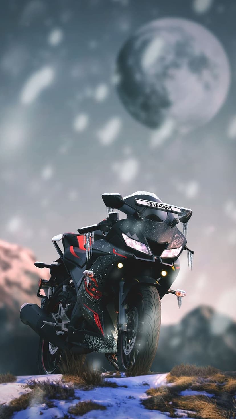Yamaha R15 motorcycle covered in frost and snow under a glowing full moon in a dark, winter night landscape.