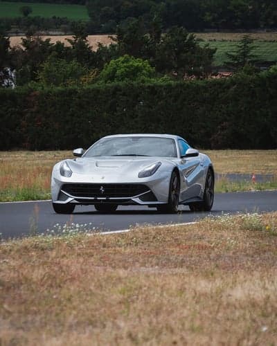 Silver Ferrari Racing on Forest Track Mobile Wallpaper