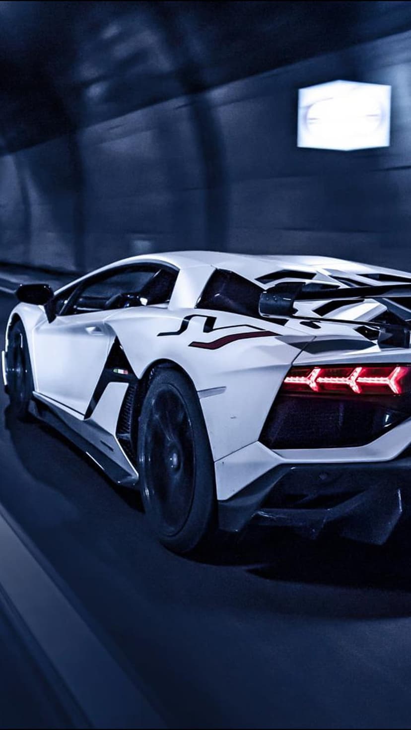 White Lamborghini Aventador with red taillights speeding through a dark tunnel with cinematic motion blur.