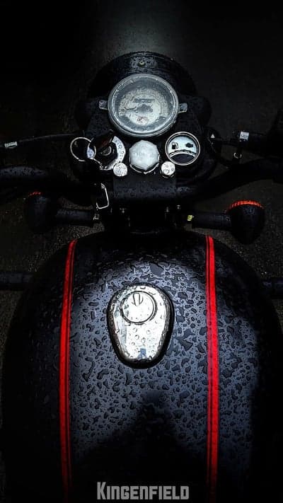 Raindrops on Classic Black Motorcycle Fuel Tank and Dashboard