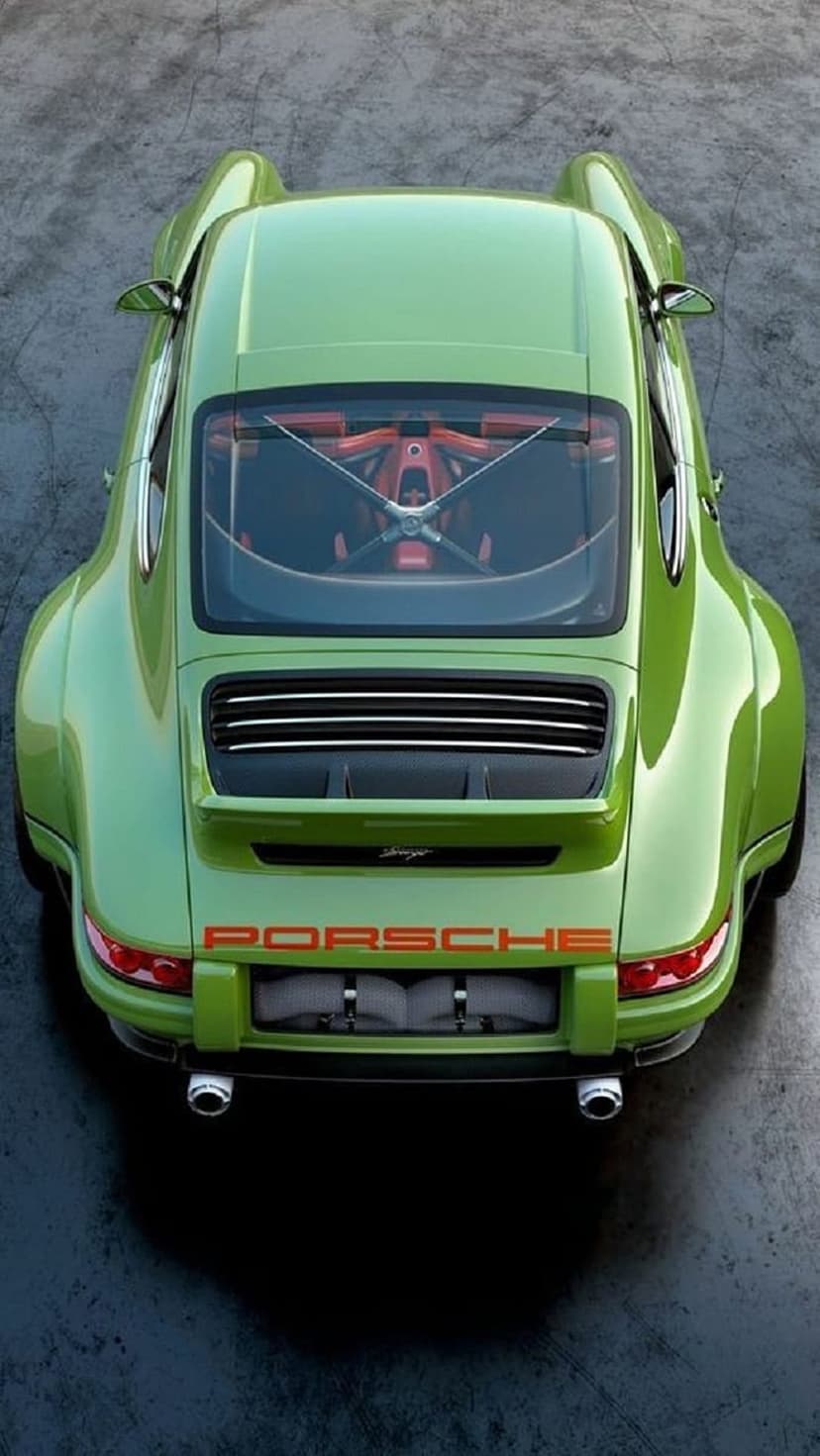 Porsche 911 in lime green viewed from above, featuring orange lettering on the rear and visible engine components.