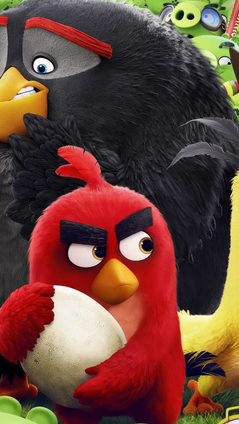 Red holds a white egg while Bomb and Chuck stand before surprised green pigs in a cinematic character group shot.