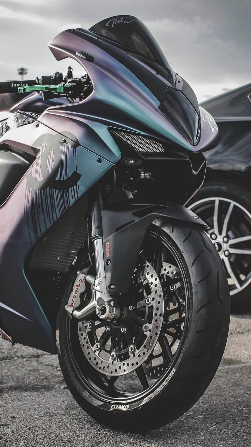 Custom sports motorcycle with iridescent purple paint, Chanel logo, Brembo brakes, and a dripping effect.