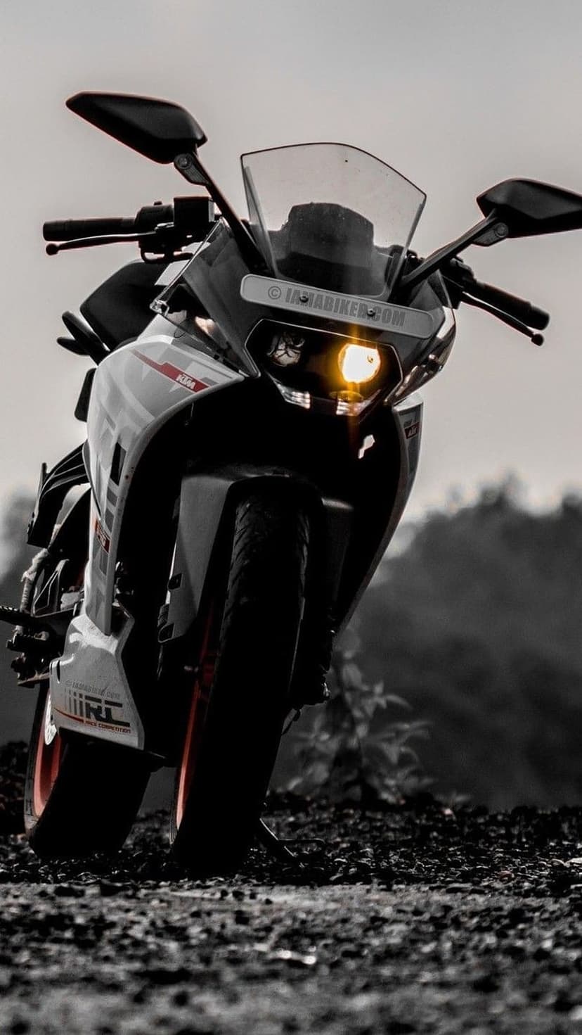KTM RC 390 sportbike headlight glowing in a dark setting with sharp orange fairings and a bokeh background.