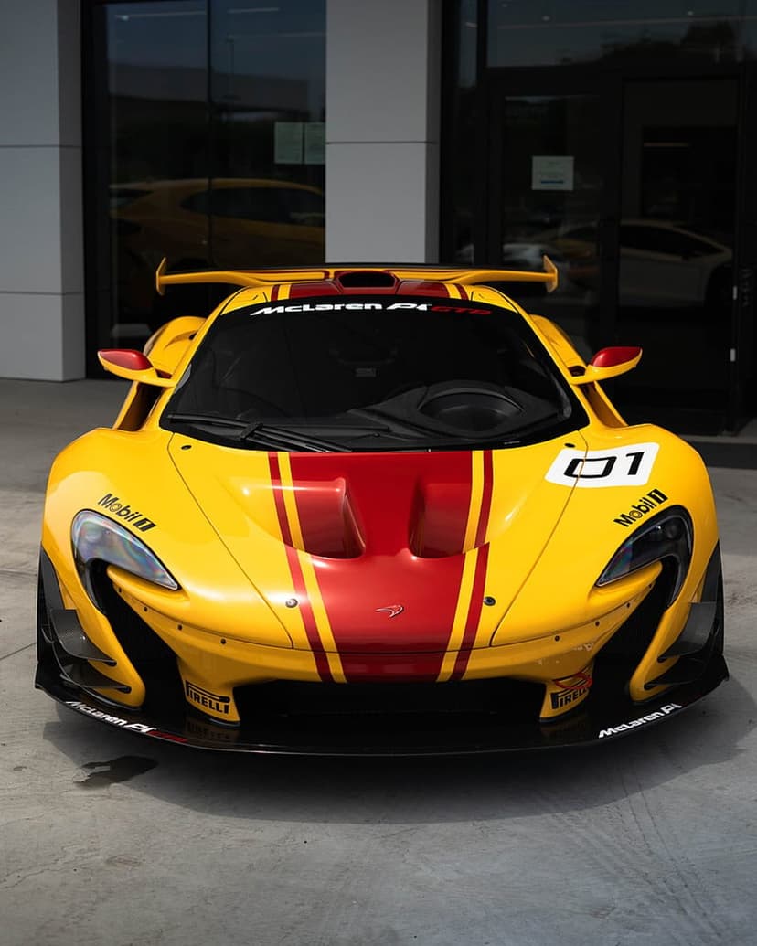 Yellow McLaren P1 GTR track car with red stripes, carbon fiber aerodynamics, and racing decals on a white ground.