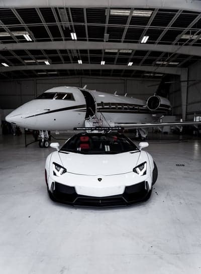 Luxury White Jet and Sports Car in Hangar