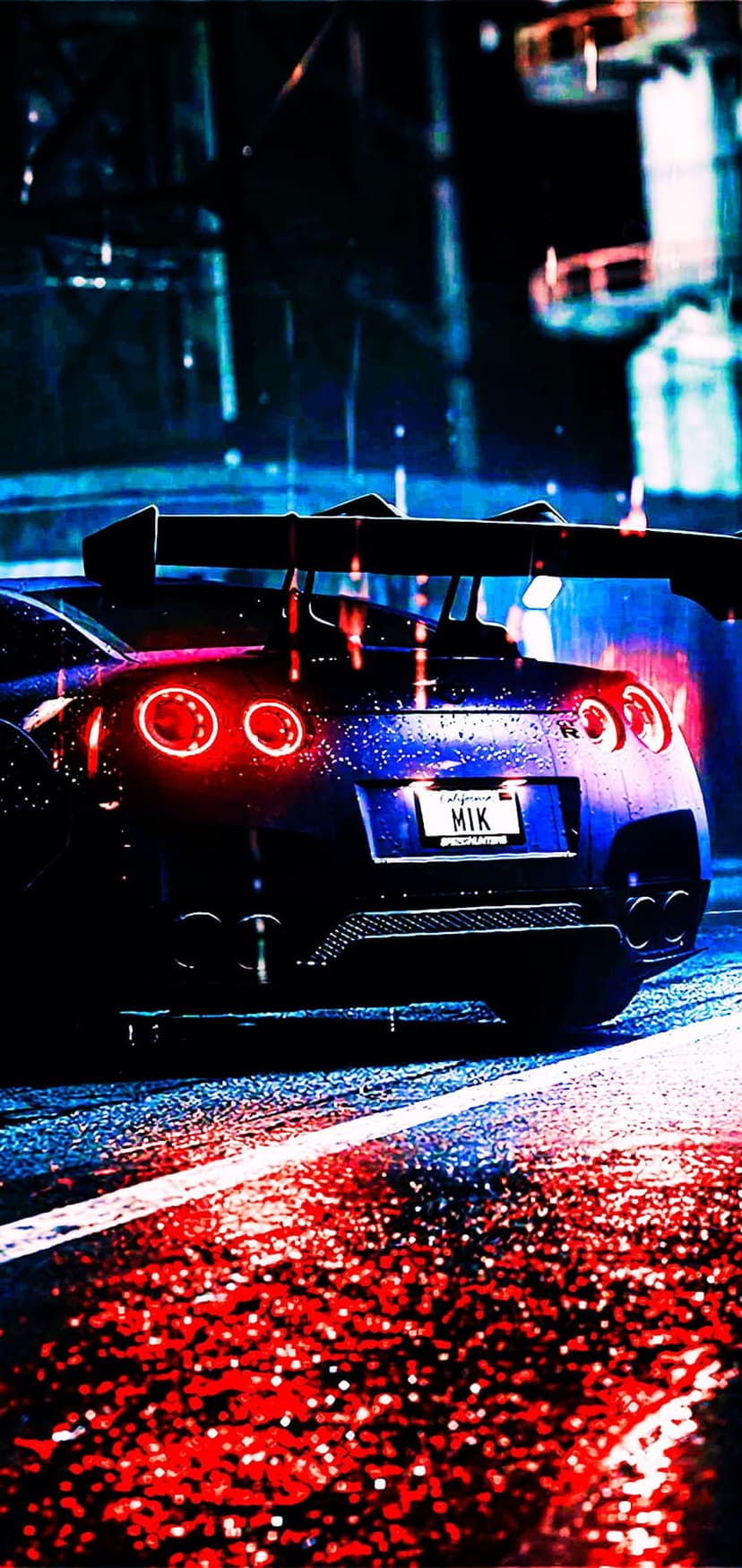 Nissan GT-R rear view with glowing red taillights on a wet city street at night with neon blue reflections.