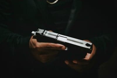 Person Holding a Handgun in Low Light