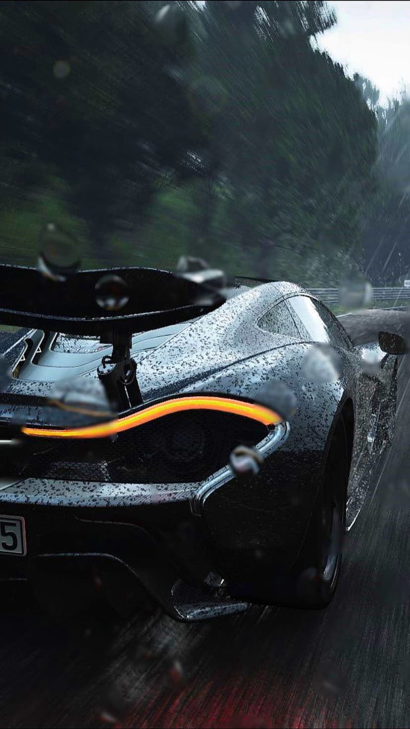 Black McLaren P1 supercar with glowing orange taillights driving on a wet race track during a heavy rainstorm.