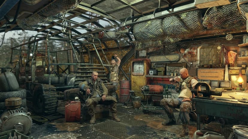 Three men in a cluttered post-apocalyptic workshop with rusty tools, a buggy, and a vintage gas pump.