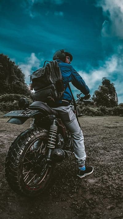 Rider on Motorcycle in Scenic Landscape Under Cloudy Sky