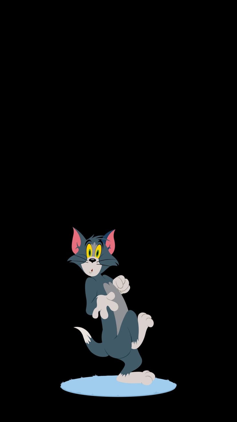 Tom the Cat with wide yellow eyes stands on a light blue oval against a solid pitch black backdrop in this pose.