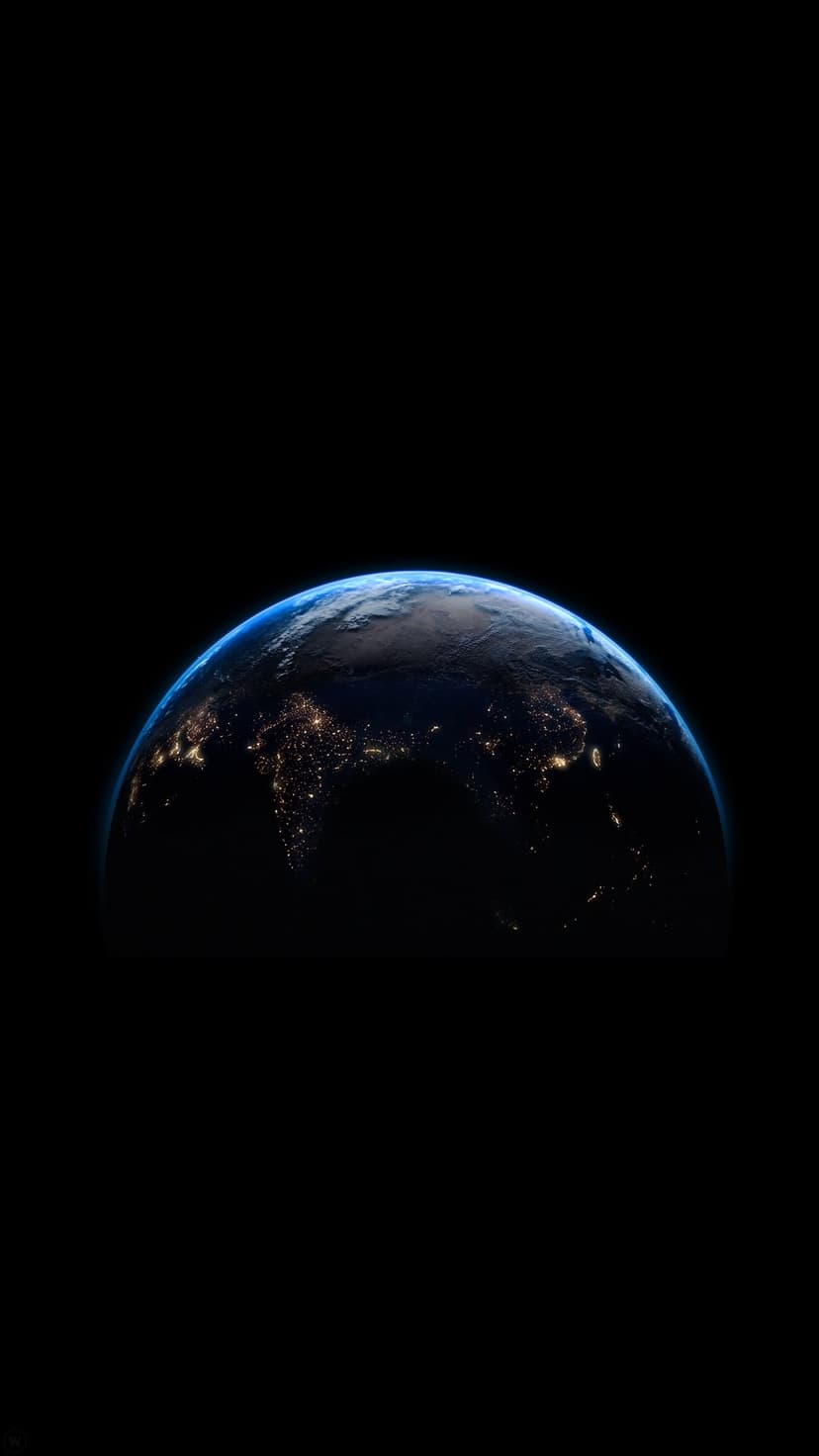 Glowing city lights sprawl across the dark curved surface of Earth as seen from space under a thin blue atmosphere.