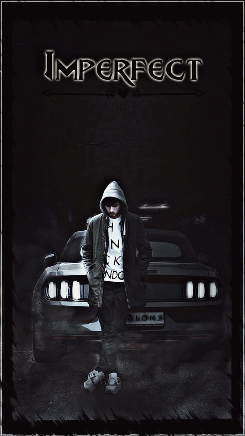 Young man in a hoodie leaning on a car with stylized Imperfect text above and an Alone license plate below.