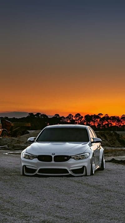 Sleek White BMW M4 Sunset Construction Mobile Background