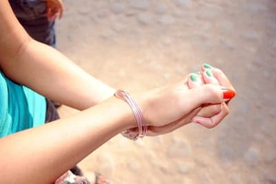 Hands clasped with green and red nail polish