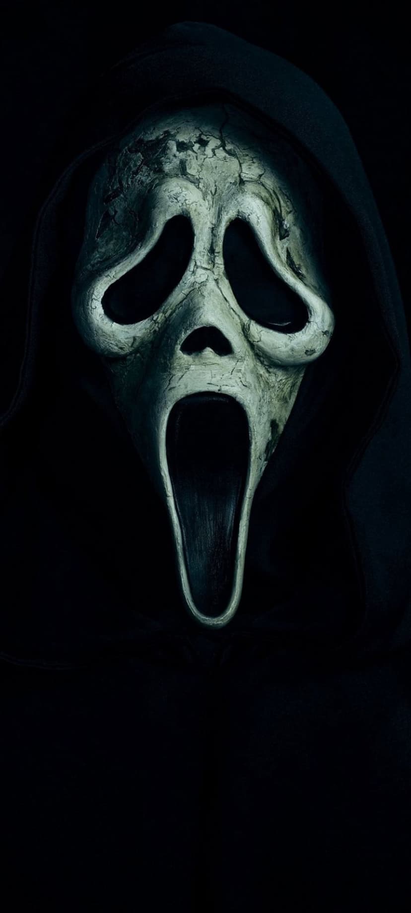Ghostface mask with cracked white paint and a long screaming mouth centered against a dark, shadowy background.