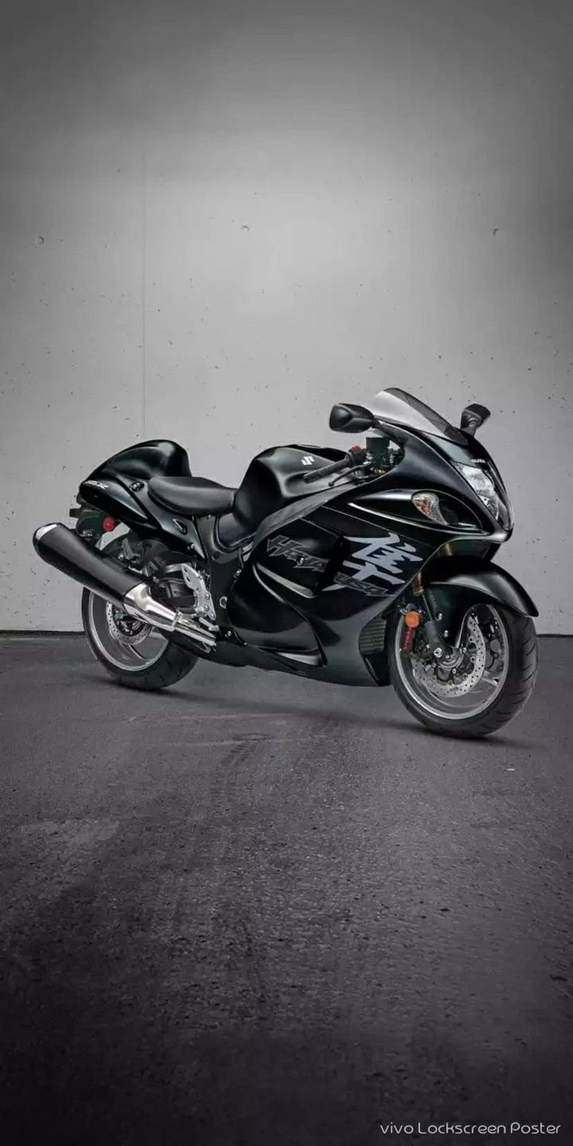 Suzuki Hayabusa motorcycle in black parked against a textured gray concrete wall with a side profile view.
