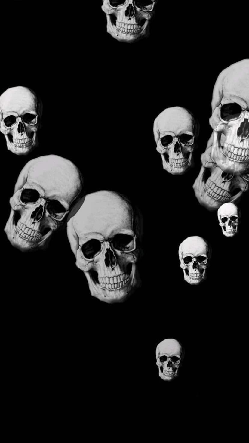 Human skulls in varying sizes and angles scattered across a solid black background with high-contrast lighting.