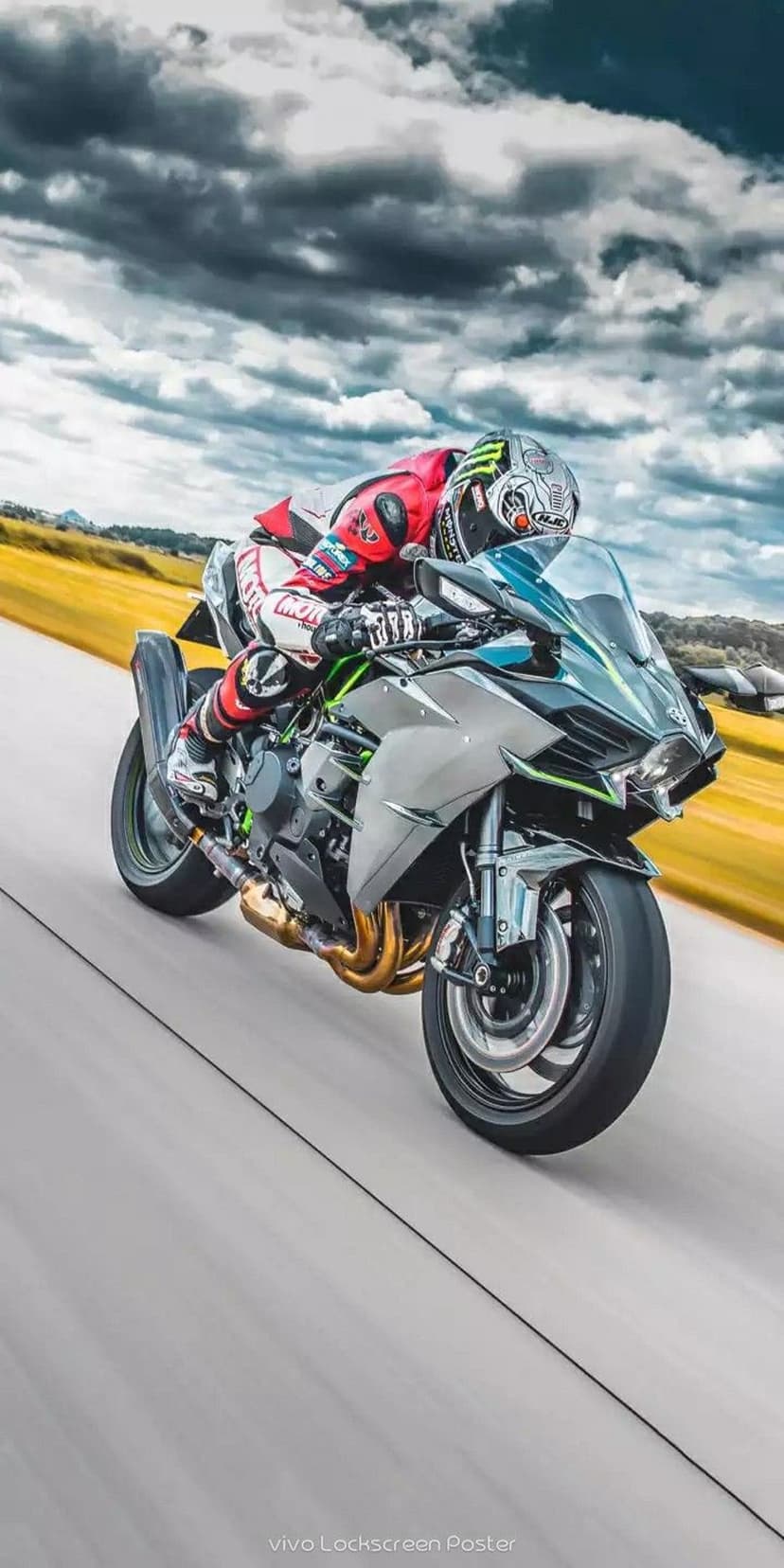 Professional racer leans a Kawasaki Ninja H2R superbike through a track curve against a blurry gray sky.