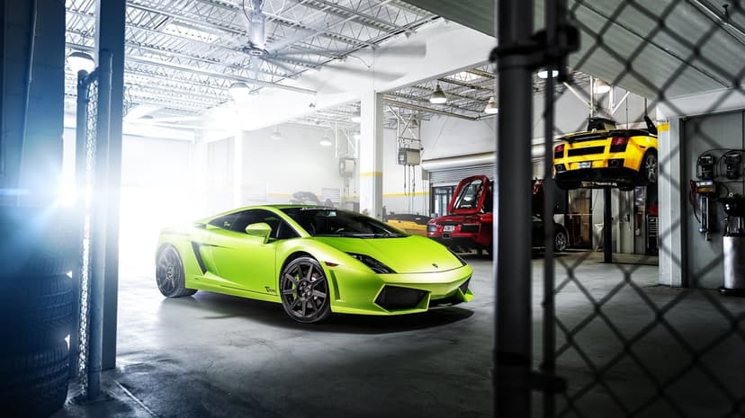 Lime green Lamborghini Gallardo in a bright white garage with yellow and red supercars in the background.