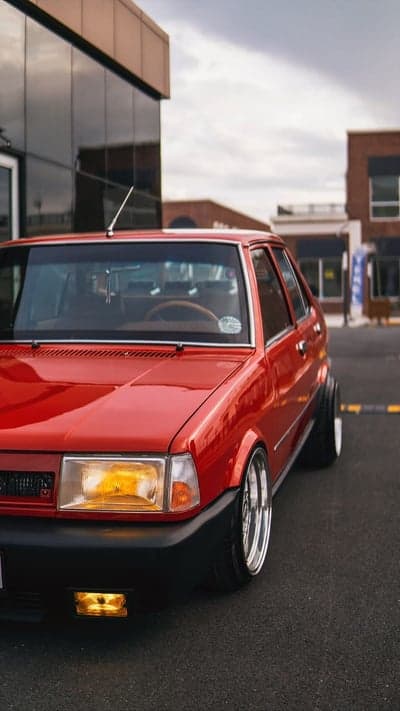 Red vintage car with custom wheels parked