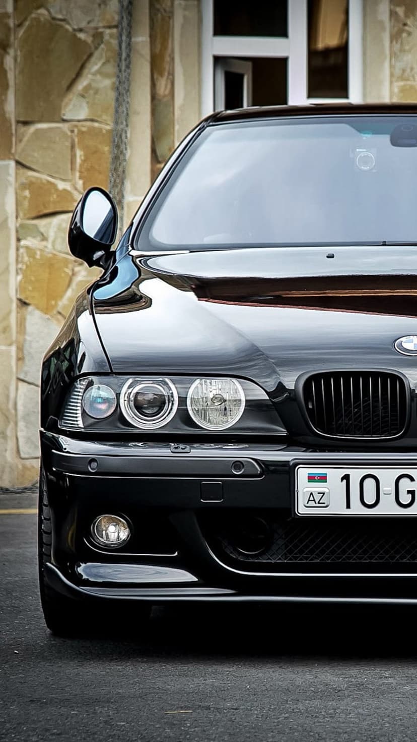 Black BMW E39 M5 front view featuring angel eye headlights, kidney grilles, and an Azerbaijani license plate.