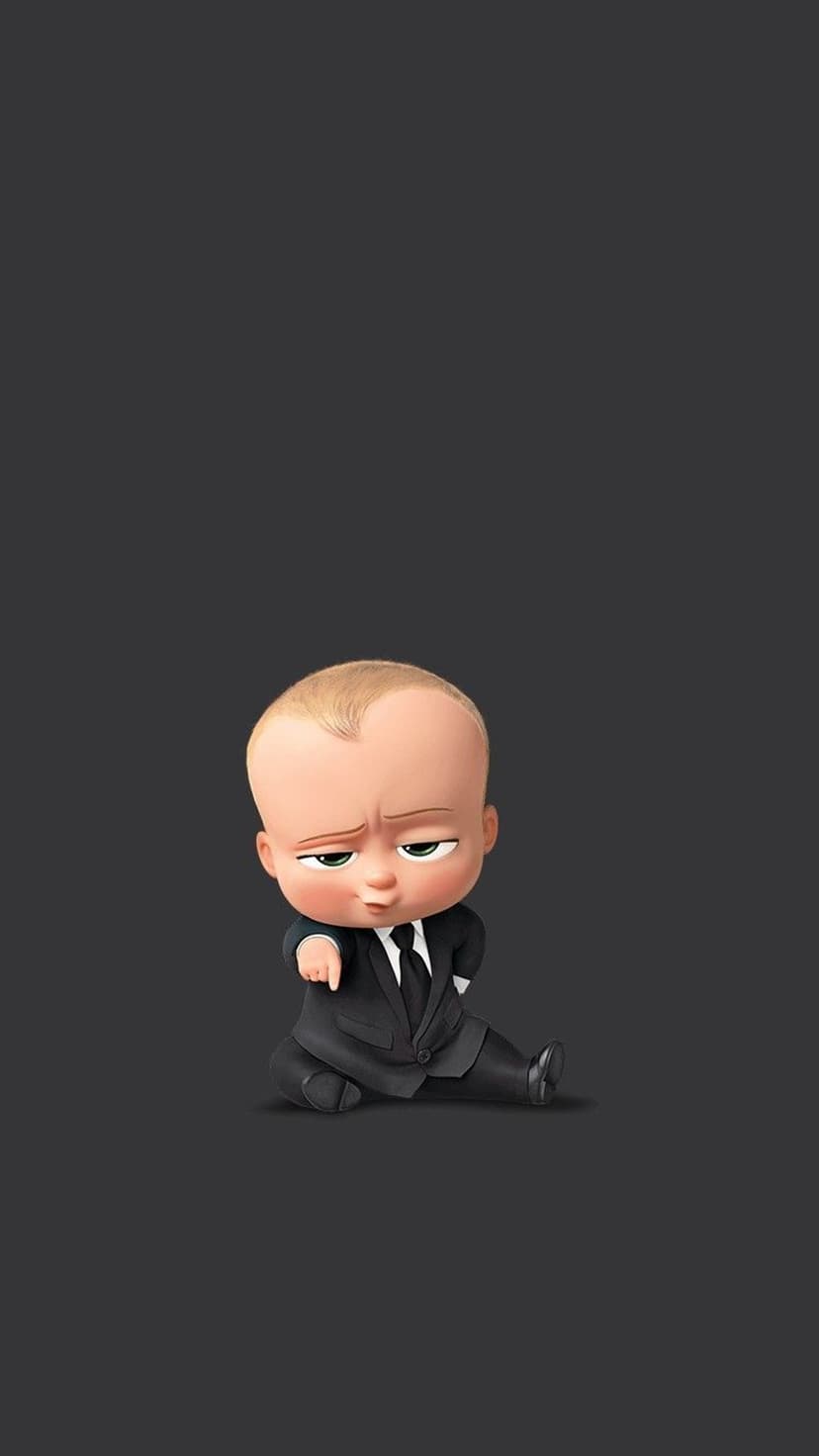 Boss Baby in a black suit points forward with a stern expression against a solid dark grey background.