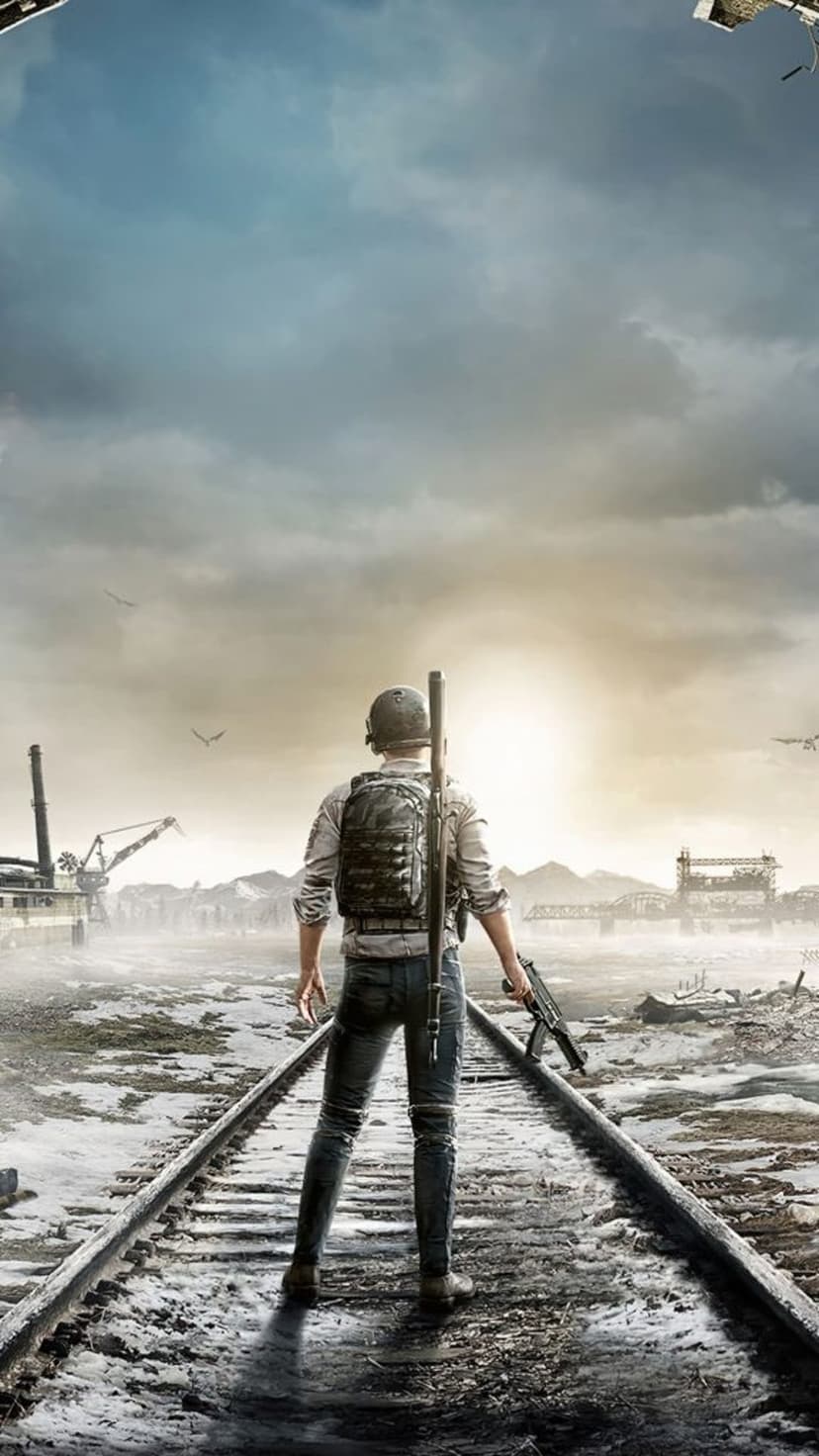 Lone soldier with a rifle and backpack stands on abandoned train tracks looking at ruins under a moody sky.