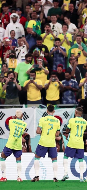 Brazil footballers celebrate goal with fans in stadium
