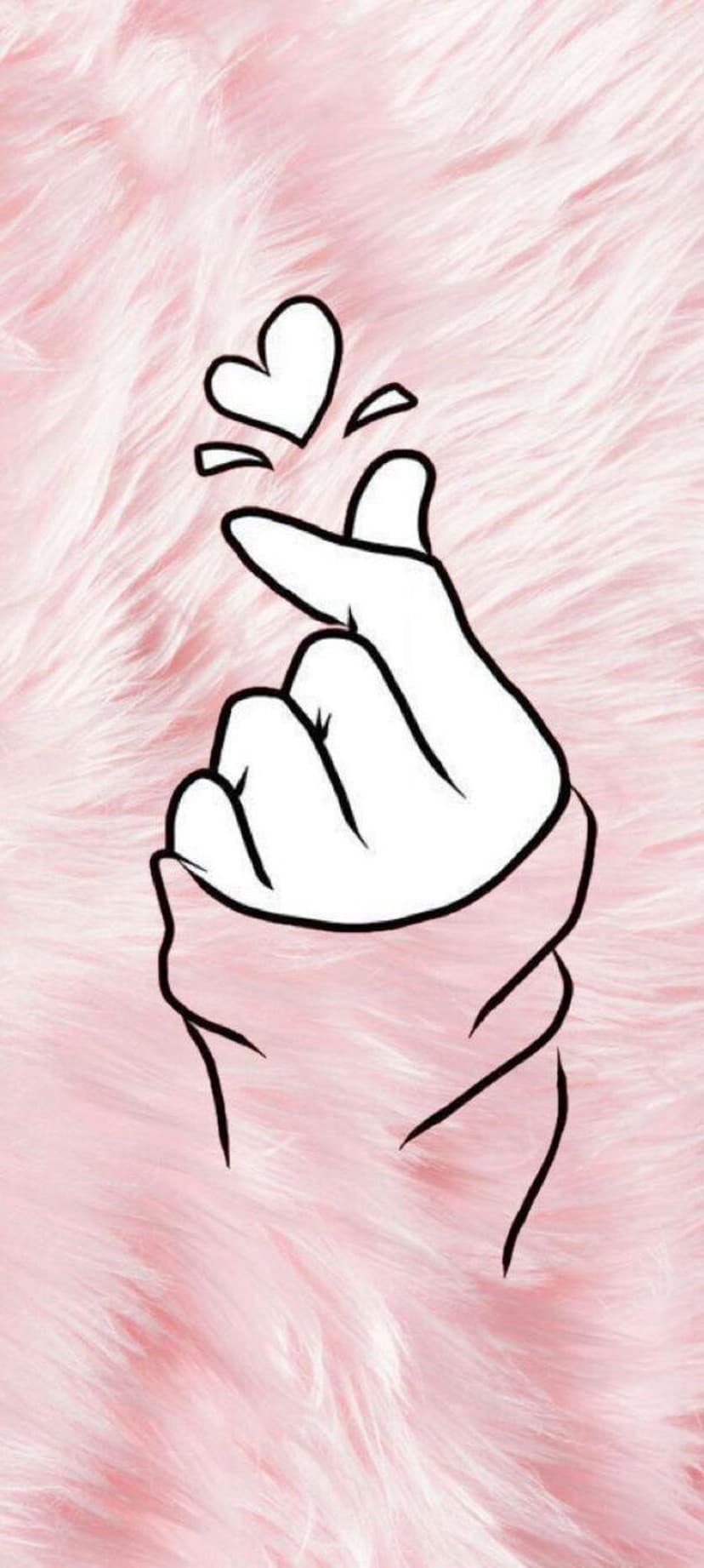 Human hand making a small finger heart gesture against a soft, textured pink background with a plush surface.