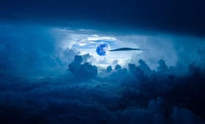 Surreal Cobalt Moon Glowing Through Dark Storm Clouds