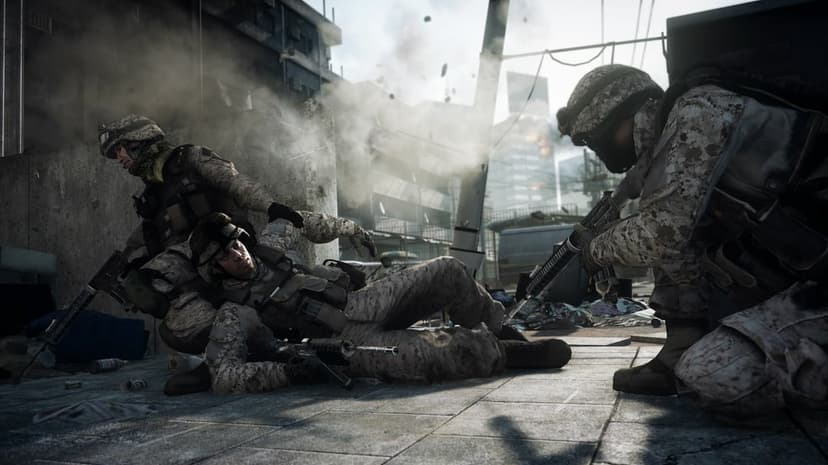 Soldiers in desert camouflage tactical gear crouch in a smoky urban battlefield with rubble and ruins.