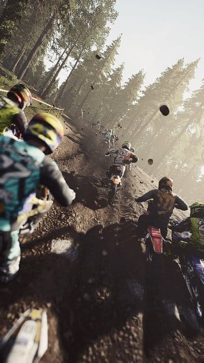Motocross Racers Descend Forested Hill in Intense Race