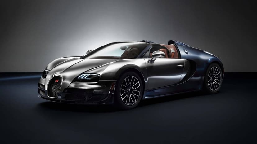 Silver and dark blue Bugatti Veyron Grand Sport Vitesse supercar in a studio with soft overhead lighting.