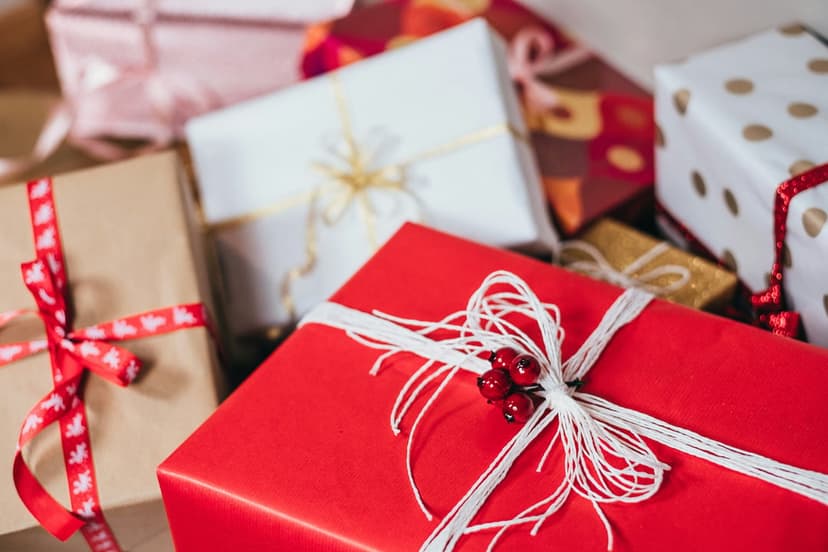 Christmas gift boxes wrapped in red and white paper with silk ribbons and kraft paper textures in a close-up.