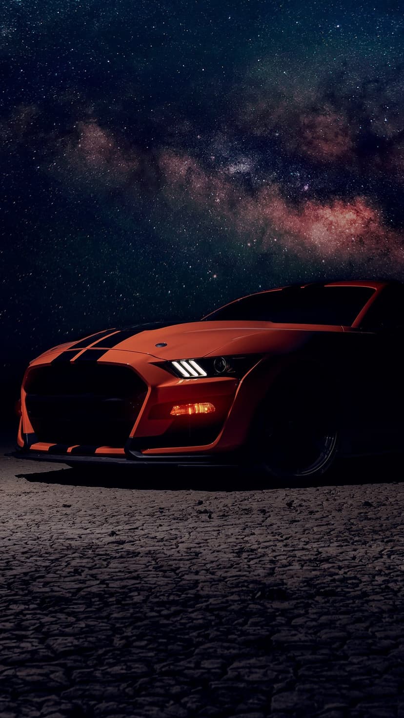 Orange muscle car with black stripes parked under a purple Milky Way galaxy filled with glowing stars.