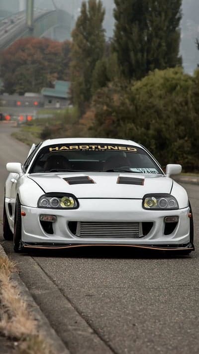 White Toyota Supra slammed on a street with Hardtuned banner