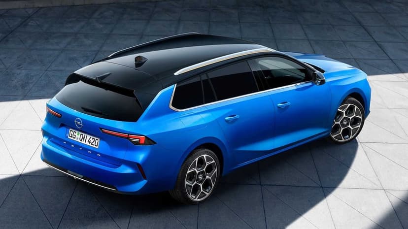 Blue Opel Astra station wagon with black roof and alloy wheels parked on a patterned gray tile floor in daylight.