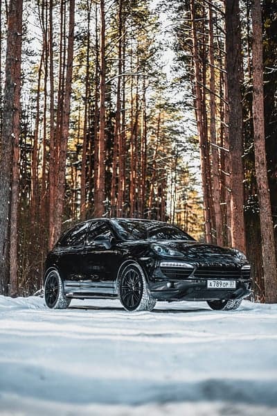 Black Porsche Cayenne in Snowy Forest