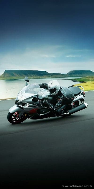 Motorcyclist racing on a scenic road with mountains