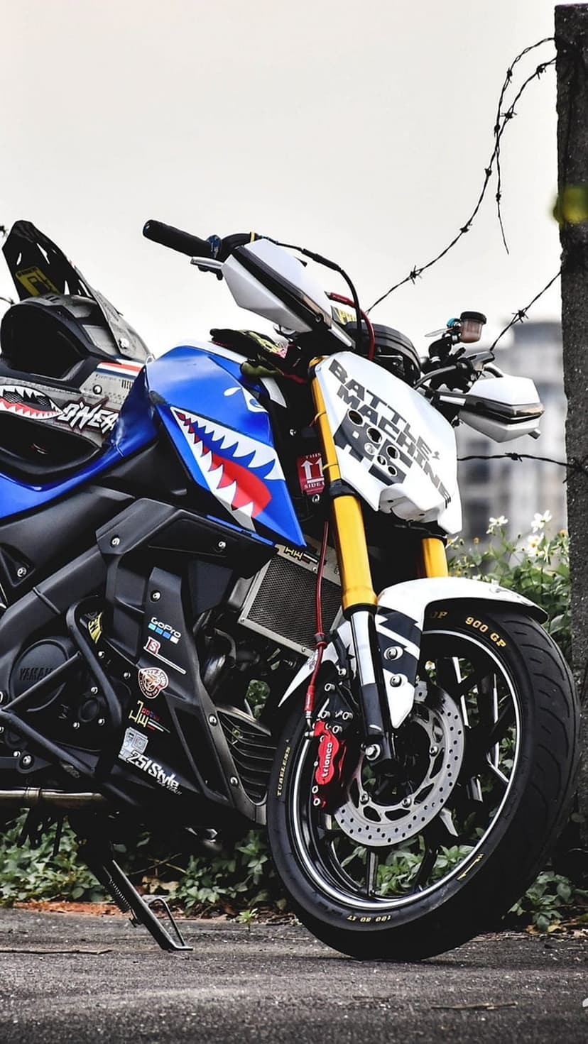 Yamaha sportbike with shark teeth graphics, yellow forks, and Battle Machine text on a white fairing.