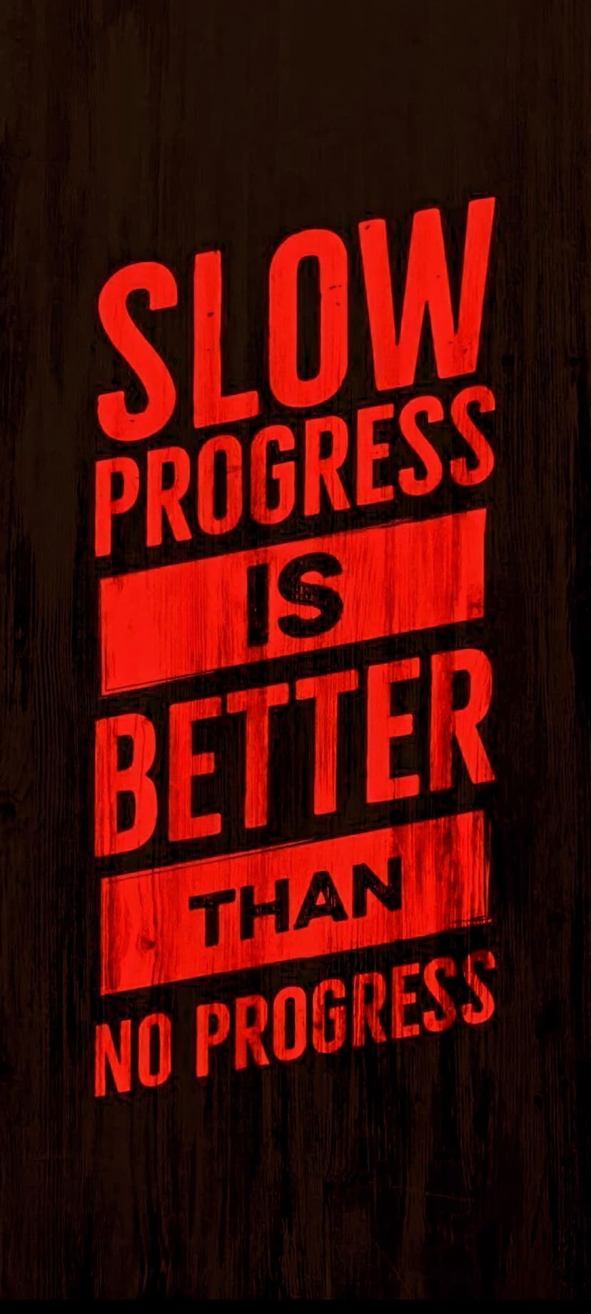 Red typography quote saying slow progress is better than no progress on a dark textured wood background.