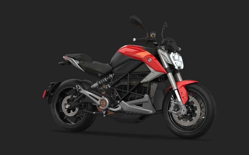 Red electric motorcycle with a black trellis frame and silver accents on a solid dark grey background.