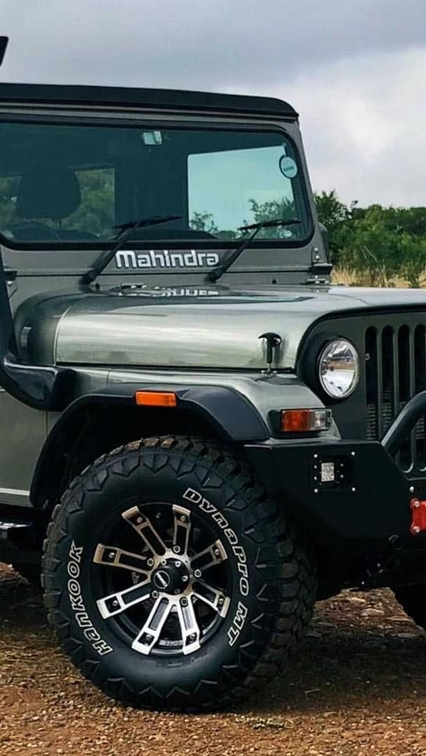 Mahindra Thar front tire with deep treads and black grille captured in a detailed vertical off-road composition.