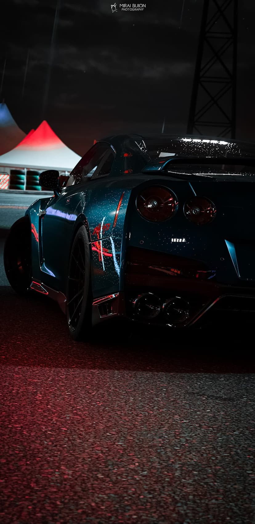 Nissan GT-R rear view at night with raindrops reflecting red and blue neon lights in a dark urban setting.