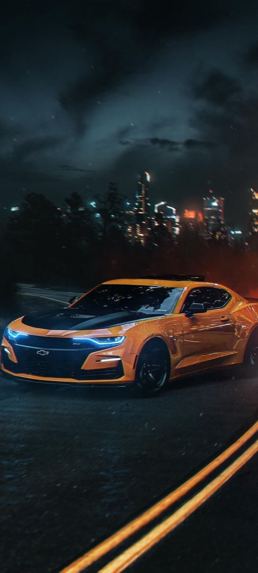 Orange Chevrolet Camaro with glowing blue headlights speeds through a dark urban environment with blurred city lights.