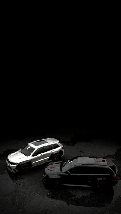 Two SUVs on wet asphalt with reflections