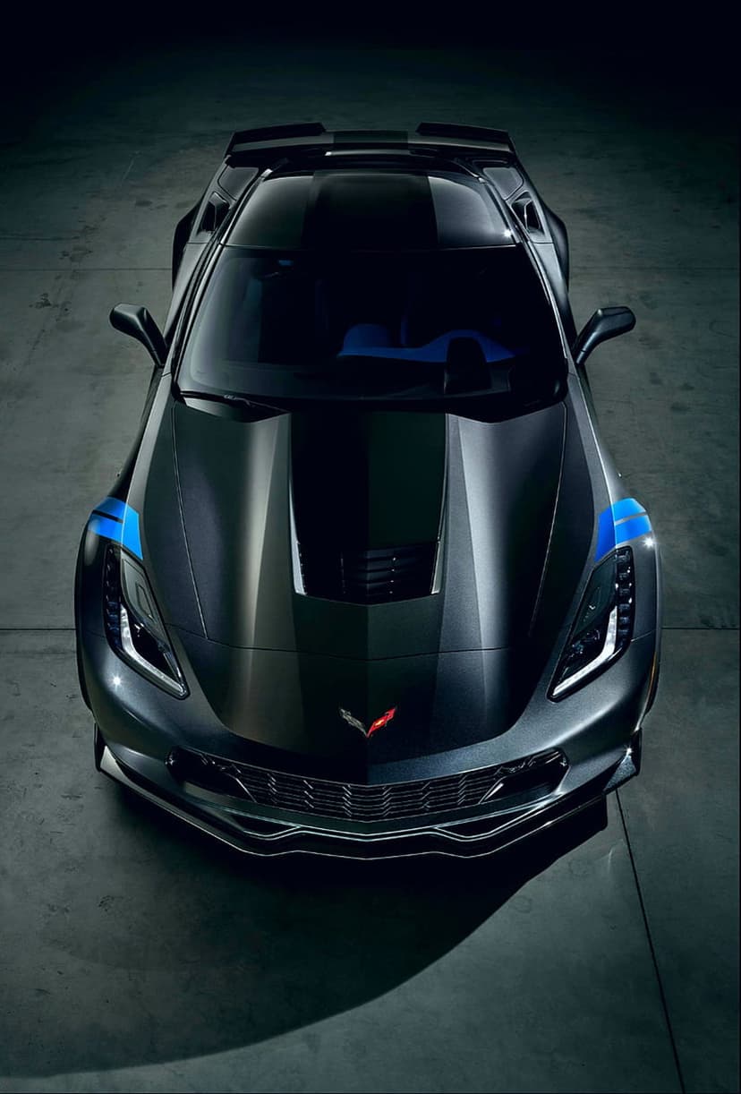 Dark gray Chevrolet Corvette C7 seen from above featuring vibrant blue racing stripes on the hood and roof.