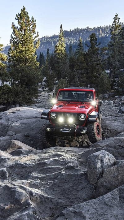 Red Jeep Wrangler Off-Roading on Rocky Terrain